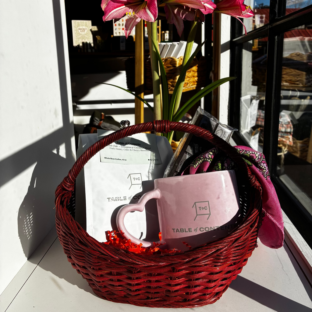 Pink mug with red flowers in a basket on a windowsill